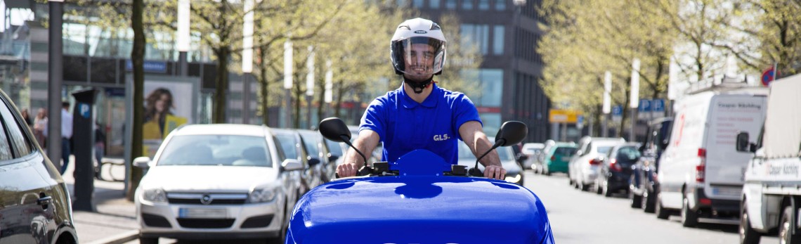 Un employé GLS livre en vélo électrique