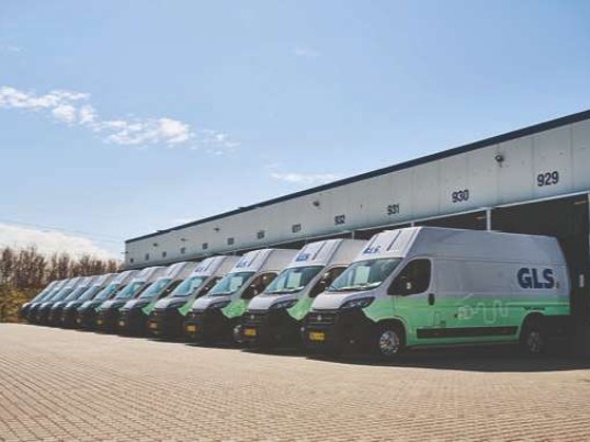 Line of electric GLS vans at a depot