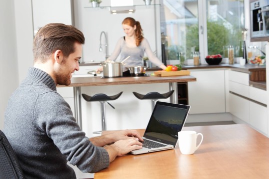 Man at a kitchen looking at GLS website