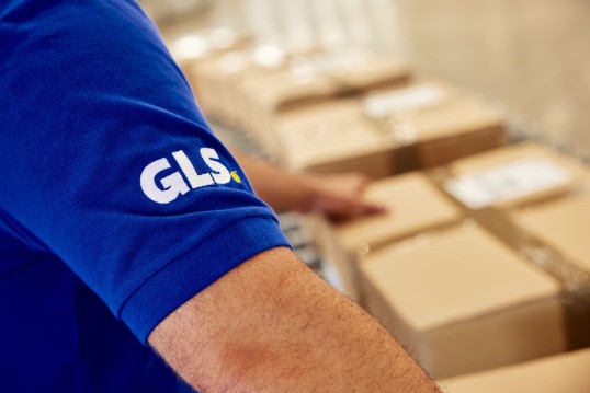 GLS-medewerker in een depot met een pakket