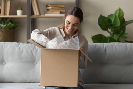 happy woman is opening her parcel